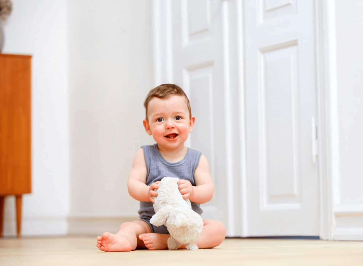 baby sitting on floor with toy ttc fertility blog